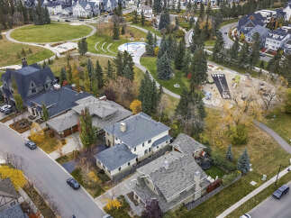 Discover this stunning aerial view of a suburban neighborhood, showcasing a collection of modern and traditional homes nestled amongst mature trees and vibrant autumn foliage.