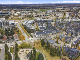 Discover this stunning aerial view showcasing a vibrant community with a mix of modern apartment buildings and charming single-family homes.