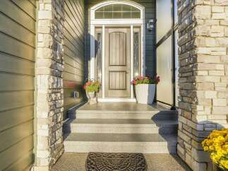 Welcome guests to your stunning home with this elegant entryway, featuring a grand arched doorway framed by decorative glass sidelights and a transom window.