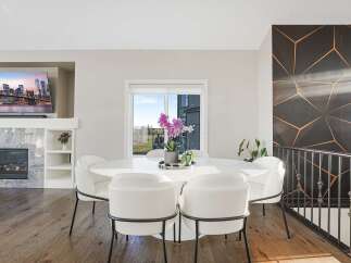 Experience modern elegance in this dining area, featuring a sleek white marble-top dining table surrounded by plush white chairs with black accents.