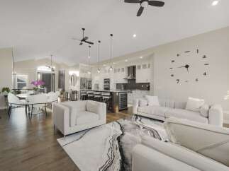 Experience modern living in this stunning open-concept home, featuring a spacious living area with a large abstract rug and comfortable seating.