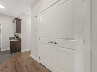 Step into this inviting hallway, featuring a sleek dark wood cabinet and countertop area, perfect for a mudroom or pantry.