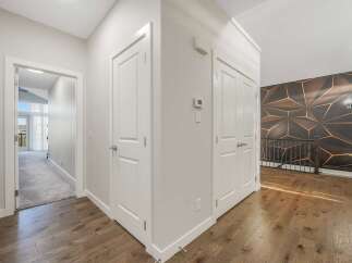 Step into this elegant hallway featuring a striking geometric accent wall that adds a modern flair.