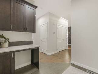 This home features a stylish built-in desk area with dark wood cabinetry and a speckled countertop, perfect for a home office or study nook.