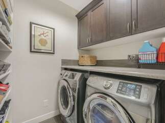This laundry room boasts modern Samsung washer and dryer units, ensuring efficient and convenient laundry days.