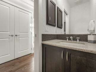 Step into a beautifully appointed bathroom featuring a sleek vanity with a granite countertop and modern fixtures.