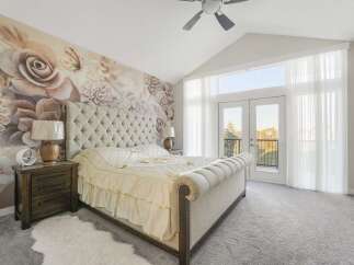 Experience luxurious comfort in this master bedroom, featuring a stunning floral mural accent wall that adds a touch of elegance and romance.