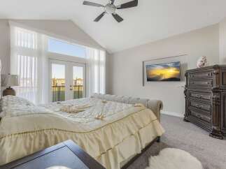 Experience luxurious living in this master bedroom featuring a vaulted ceiling and a ceiling fan for optimal comfort.