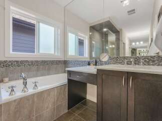 Experience luxury in this stunning bathroom featuring a deep soaking tub with elegant chrome fixtures, perfect for unwinding.