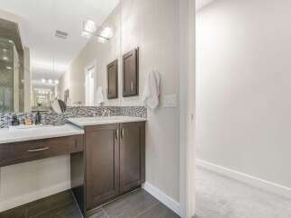 Experience luxury in this master bathroom, featuring a spacious vanity with ample counter space and elegant dark wood cabinetry.