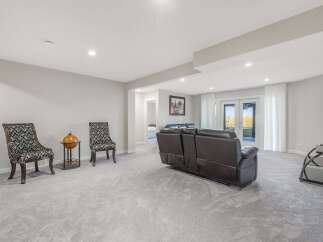 Step into this inviting living space, featuring plush grey carpeting that extends throughout the room.