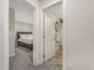 Step into a well-appointed living space featuring a comfortable bedroom with a plush carpet and a spacious bed.