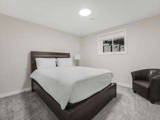 This bedroom features a comfortable queen-size bed with crisp white linens, perfect for a restful night's sleep.