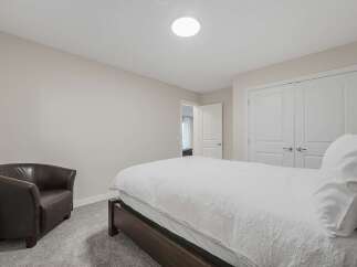 This inviting bedroom features a comfortable queen-size bed with crisp white linens, perfect for restful nights.