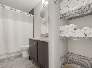 This modern bathroom features a sleek vanity with ample storage and a granite countertop.