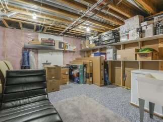 This basement offers ample storage solutions with numerous boxes and shelving units.