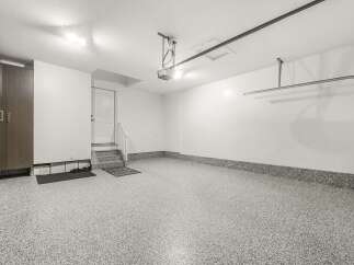 This spacious garage features a durable, speckled epoxy floor that is both attractive and easy to clean.