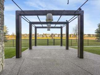 Discover this charming property featuring a modern pergola with hanging lights, perfect for outdoor gatherings.