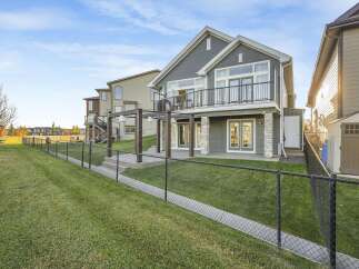 Enjoy the outdoors from this stunning home featuring a spacious backyard with a covered patio and a balcony overlooking the manicured lawn.