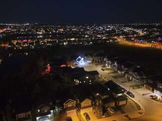 Experience the magic of this stunning aerial night view of a suburban neighborhood adorned with festive lights.