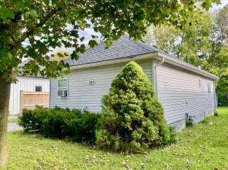 Discover this charming home featuring a classic gray vinyl siding and a dark shingle roof, offering a timeless appeal.