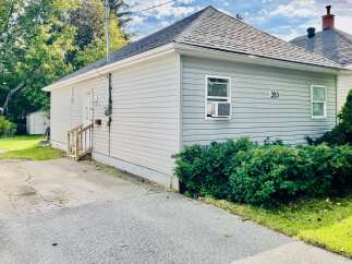 Charming single-family home located at 285, featuring a light gray vinyl siding and a dark asphalt shingle roof.