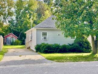 Charming single-family home featuring a light gray vinyl exterior and a dark gray shingled roof.