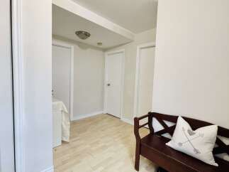 This hallway features light wood-look flooring and crisp white walls, creating a bright and airy atmosphere.