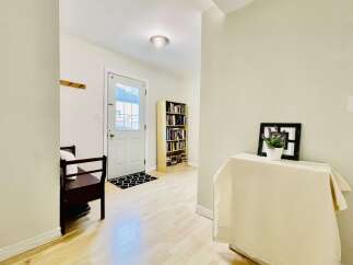Step into a welcoming entryway featuring a convenient bench for seating and a coat rack for your outerwear.