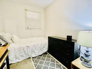 This cozy bedroom features a comfortable twin bed with crisp white linens, perfect for a single occupant.