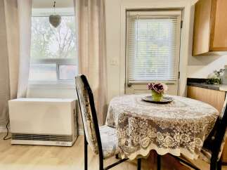Enjoy cozy meals in this charming dining nook, featuring a round table draped with an elegant lace tablecloth.