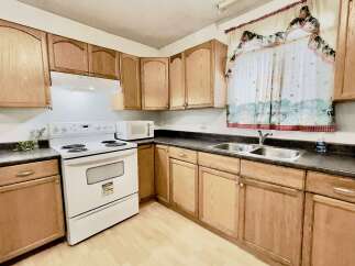 This charming kitchen features light oak cabinetry, providing ample storage space and a warm, inviting aesthetic.