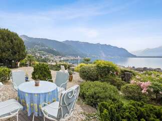 Enjoy breathtaking panoramic views of the lake and mountains from this stunning property's outdoor seating area.