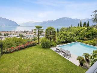 Experience luxurious living with this stunning property boasting a private swimming pool and breathtaking panoramic views of the lake and mountains.