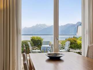 Enjoy breathtaking panoramic views of snow-capped mountains and a serene lake from this elegant dining area.