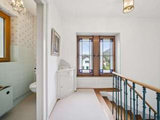 This charming hallway features a beautifully decorated window with stained glass accents, offering picturesque views of the surrounding landscape.