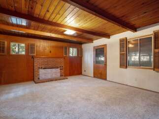 Step into this cozy living room featuring a charming brick fireplace, perfect for gathering on cool evenings.