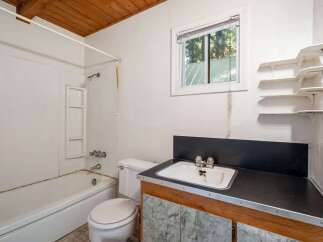 This bathroom features a classic white bathtub and toilet, perfect for a functional and clean space.