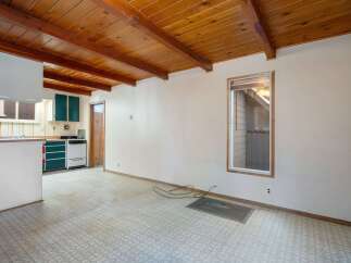 This charming home features a rustic wood-beamed ceiling that adds warmth and character to the living space.