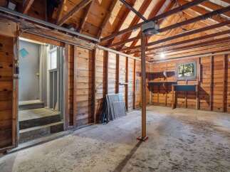 Discover the potential of this unfinished basement, featuring a sturdy wooden beam structure and a concrete floor ready for your personal touch.