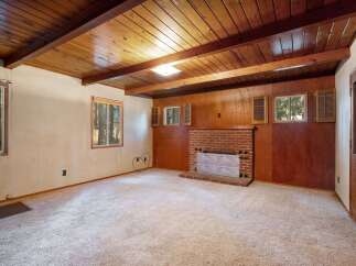 This spacious living room features a cozy brick fireplace, perfect for gathering on chilly evenings.