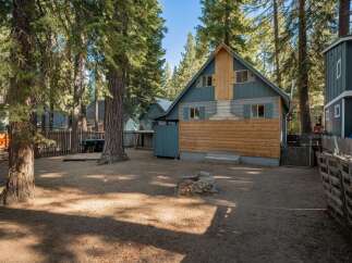Discover this charming cabin nestled among tall pine trees, offering a rustic retreat.
