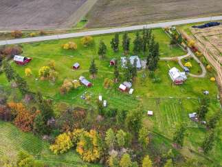 Discover this charming rural property featuring multiple red barns and outbuildings, perfect for a hobby farm or equestrian enthusiast.