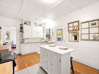 Step into this charming kitchen, featuring crisp white cabinetry and a spacious island perfect for meal prep and casual dining.
