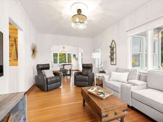 Step into this inviting living room, featuring plush leather recliners and a comfortable gray sofa, perfect for relaxation.