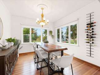 Experience elegant dining in this bright and airy room, featuring a live-edge wood dining table and comfortable white chairs.