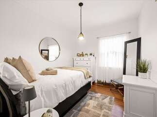 Step into this charming bedroom, featuring a comfortable bed adorned with plush pillows and a cozy throw blanket.