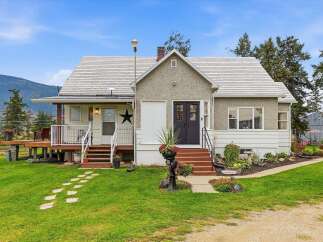 Charming home nestled against a backdrop of rolling hills and mature trees.