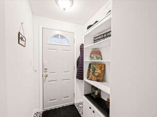 Welcome guests into a charming entryway featuring a classic white door with a decorative arched window.