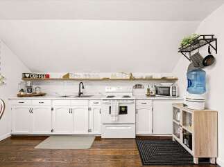 This charming kitchen features crisp white cabinetry and a sleek subway tile backsplash, creating a bright and inviting atmosphere.